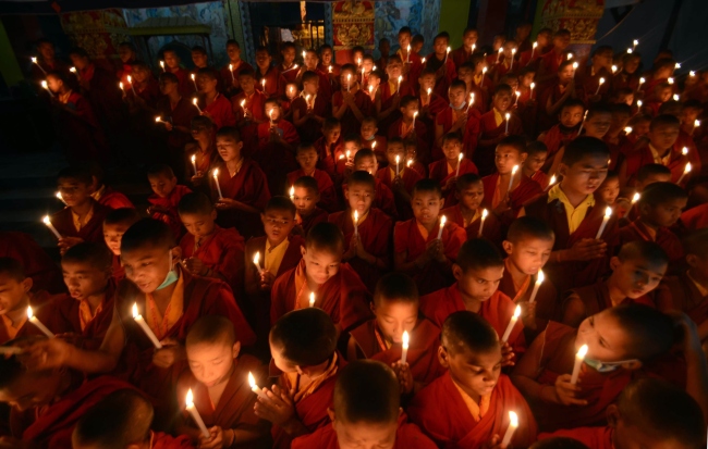 Novice Buddhist monks light candles in remembrance of an Indian woman who died after being gang raped in a moving bus, in Bodhgaya, India, Sunday. (AP-Yonhap News)