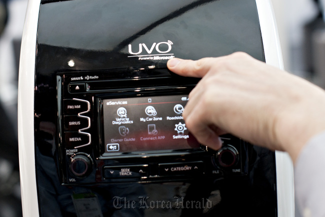 A company representative discusses a UVO system, an in-car interface developed by Microsoft Corp. and Kia Motors Corp., at the Kia booth during the 2012 International Consumer Electronics Show in Las Vegas on Jan. 13.   Bloomberg