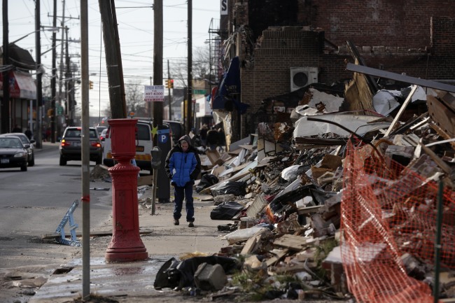 <YONHAP PHOTO-0258> A man walks past a small commercial strip that burned down during Superstorm Sandy in the Rockaways section of New York, Wednesday, Jan. 2, 2013. House Speaker John Boehner's decision to cancel an expected vote Tuesday night on aid for Superstorm Sandy victims had outraged lawmakers from New York, New Jersey and elsewhere, including many in his own party. (AP Photo/Seth Wenig)/2013-01-03 08:33:59/ <저작권자 ⓒ 1980-2013 ㈜연합뉴스. 무단 전재 재배포 금지.>
A man walks past a small commercial strip that burned down during Superstorm Sandy in the Rockaways section of New York on Wednesday.   AP-Yonhap News