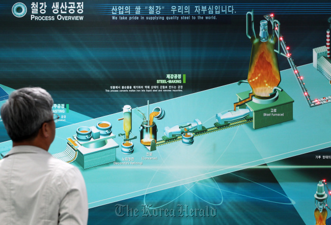 A visitor looks at a display showing an overview of the steel process at POSCO’s showroom in Seoul.   Bloomberg