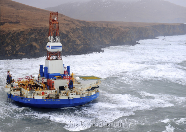 This aerial image provided by the U.S. Coast Guard shows the Royal Dutch Shell drilling rig Kulluk aground off a small island near Kodiak Island Tuesday.   AP-Yonhap News