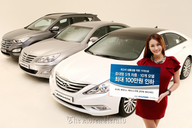 A model poses with (from left) the Santa Fe, Genesis and Sonata models of Hyundai Motor.   Hyundai Motor