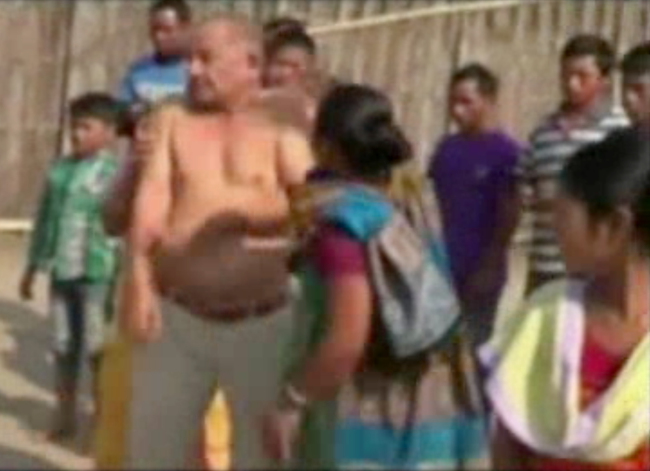 In this image taken from video obtained from Network 1 News and Information Syndicate (NNIS), which has been authenticated based on its contents and other AP reporting, Bikram Singh Brahma, center, a leader of India's ruling Congress party, is slapped by a woman in the village of Santipur, India, on Thursday. (AP-Yonhap News)