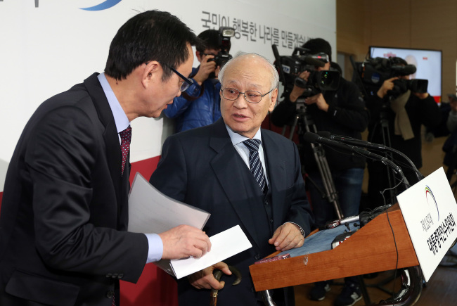 Transition committee chief Kim Yong-joon (right) talks with spokesman Yoon Chang-jung during the press conference to announce the names of committee members at the committee headquarters in Samcheong-dong, Seoul, Friday.  Yonhap News