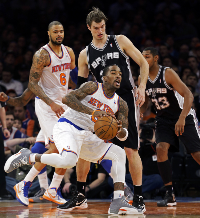 New York Knicks guard J. R. Smith (8) looks to pass against San Antonio Spurs forward Tiago Splitter (rear), as Knicks center Tyson Chandler (6) watches in the first half of their NBA basketball game at Madison Square Garden in New York on Thursday. The Knicks won 100-83.   AP-Yonhap News