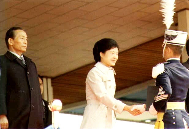 Park Geun-hye (center) shakes hands with a military cadet as she
stands in for late first lady Yook Young-soo. (Yonhap News)