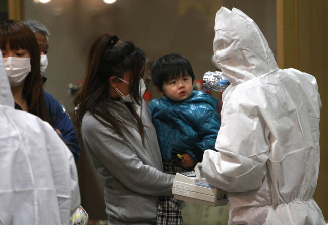 A child is screened for radiation exposure at a testing center in Koriyama city, Fukushima Prefecture, Japan, after a nuclear power plant on the coast of the prefecture was damaged by the March 11 earthquake.   AP-Yonhap News