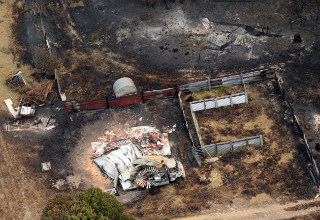 A charred vehicle sits near the remains of a home destroyed by a wildfire between Dunalley and Boomer Bay, east of the Tasmanian capital of Hobart, Australia.   AP-Yonhap News