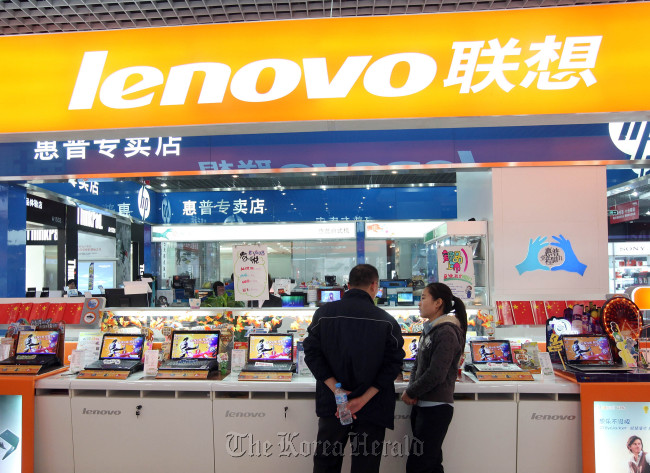 A customer looks at Lenovo Group Ltd. computers at a store in Beijing.   Bloomberg