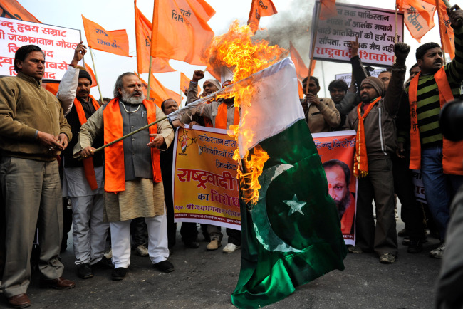 Hindu nationalist activists set a Pakistani flag on fire as they protest against Pakistan near the Feroz Shah Kotla ground in New Delhi on Sunday.   (AP-Yonhap News)