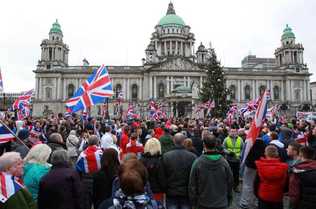 Loyalists march outside Belfast City Hall on Saturday in protest over Belfast city council’s decision to restrict the number of days the British Union Flag can be flown over the city hall.   AFP-Yonhap News