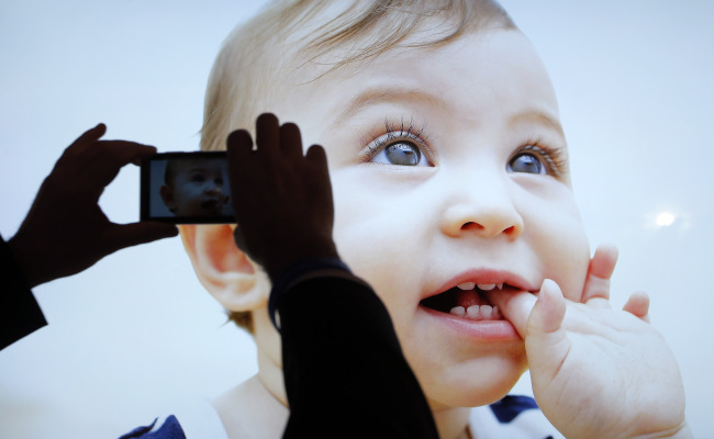 A show attendee photographs an image displayed on an LED television at the International Consumer Electronics Show in Las Vegas on Monday.   AP-Yonhap News