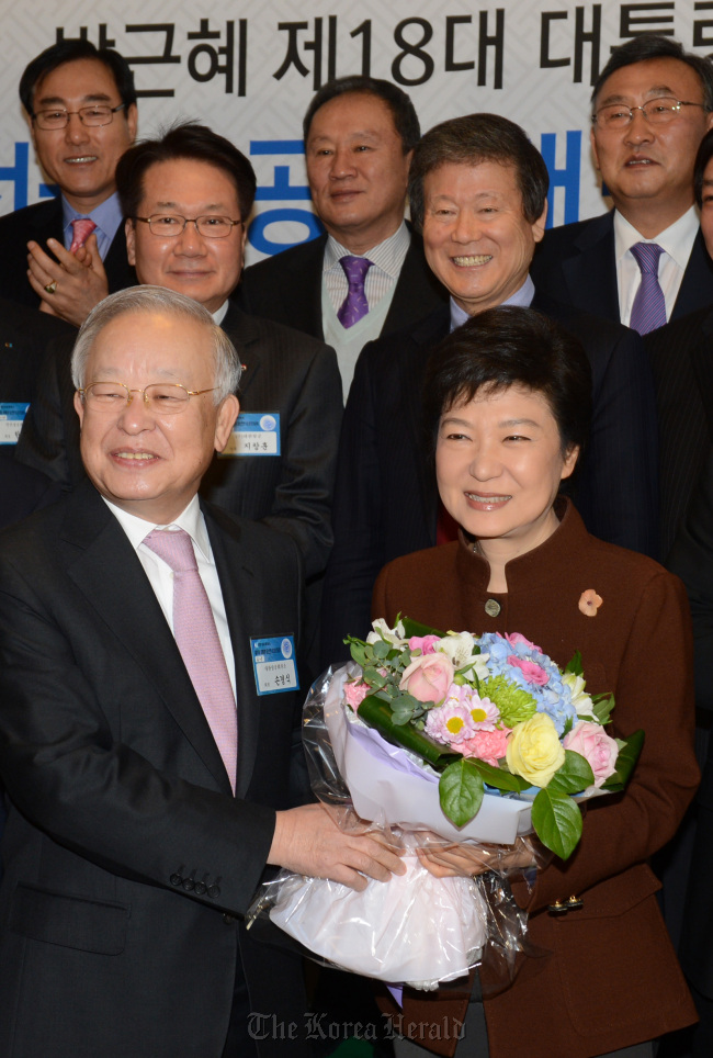 President-elect Park Geun-hye receives a bouquet from Sohn Kyung-shik, chairman of the Korea Chamber of Commerce and Industry, as she visits the KCCI for a meeting with heads of small-and medium-sized companies in Seoul on Wednesday.   Ahn Hoon/The Korea Herald
