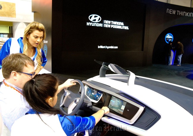 An attendee tries out smart-car technologies at Hyundai Motor’s exhibition booth at the Consumer Electronics Show in Las Vegas.   Hyundai Motor