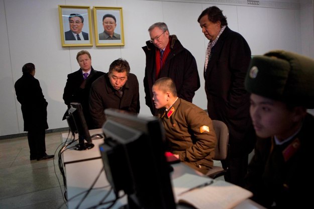 Former New Mexico Gov. Bill Richardson and Google's chairman Eric Schmidt looking at computer use of a North Korean soldier (Yonhap)
