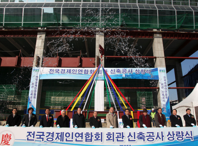 지난해 12월 열린 전경련 신축 건물 상량식에서 허창수(가운데) 회장을 비롯한 관계자가 상량식 버튼을 누르고 있다. 전경련은 올해 하반기 새 건물로 입주한다. 새 둥지를 틀며 제2의 도약을 기대하고 있지만, 변화에 대한 압박이 기다리고 있어 마냥 부푼 꿈에 들떠 있을 수만은 없어 보인다.