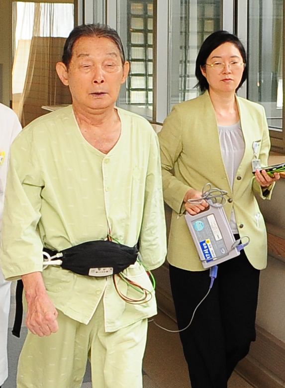 <YONHAP PHOTO-0771> 삼성서울병원, '3세대 인공심장' 이식 (서울=연합뉴스) 삼성서울병원에서 3세대 비박동형 인공 보조심장을 이식한 환자(왼쪽)가 몸 밖에 각종 작동 장치를 부착한 채 걷기 연습을 하고 있다. 2013.1.10 << 삼성서울병원 제공 >> photo@yna.co.kr/2013-01-10 10:40:56/ <저작권자 ⓒ 1980-2013 ㈜연합뉴스. 무단 전재 재배포 금지.>
Bae Jung-soo (left) exercises after receiving an artificial heart transplant operation at Samsung Medical Center.   Samsung Medical Center