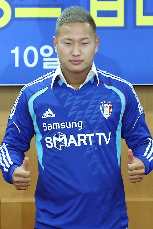 <YONHAP PHOTO-1380> '인민 루니' 정대세, 수원 삼성 블루윙즈 입단 (서울=연합뉴스) 유용석 기자 = 정대세 선수가 10일 오후 서울 신문로 축구회관에서 열린 프로축구 수원블루윙즈 입단 기자회견에서 등번호 14번 유니폼을 입고 포즈를 취하고 있다. 2013.1.10 yalbr@yna.co.kr/2013-01-10 14:37:58/ <저작권자 ⓒ 1980-2013 ㈜연합뉴스. 무단 전재 재배포 금지.>
Jong Tae-se poses with his new jersey on Thursday.
Yonhap News
