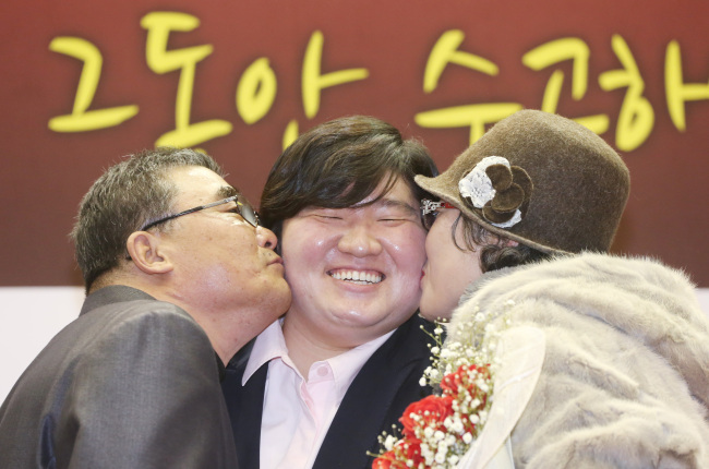 Jang Mi-ran receives a kiss from her parents during a press conference in Goyang on Thursday to announce her retirement from weightlifting.
Yonhap News
