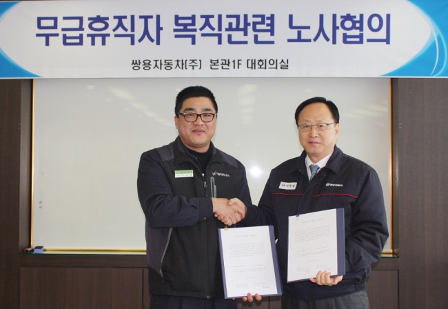Ssangyong Motor CEO Lee Yool-il (right) shakes hands with labor union leader Kim Kyu-han after signing an agreement to reinstate all workers on unpaid leave in Seoul on Thursday.   Ssangyong Motor