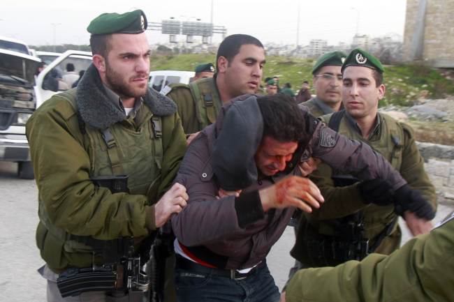 Israeli border policemen arrest a Palestinian man at the entrance of the village of Zayem, as he was on his way to join an outpost between Jerusalem and the Jewish settlement of Maale Adumim in the Israeli-occupied West Bank on Saturday.   AFP-Yonhap News