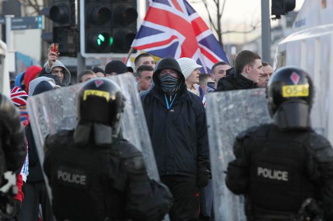 Police in riot gear try to contain Union Flag-waving loyalist protesters during clashes in east Belfast, Northern Ireland, Saturday.   AFP-Yonhap News