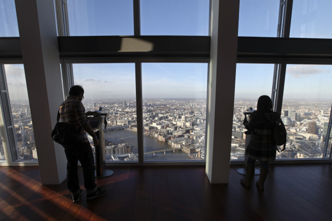 Visitors look at information displays at The View From The Shard, a series of viewing galleries looking over the capital, near the top of The Shard tower in London.   Bloomberg-Yonhap News