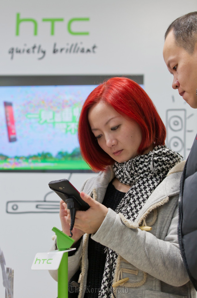 Customers try out an HTC Corp. Butterfly smartphone at one of the company’s stores in Taipei.   Bloomberg