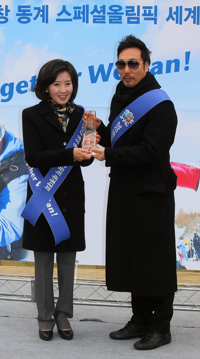 나경원(변호사/전국회의원),이문세(가수)
Chairwoman of the Special Olympics Organizing Committee Na Kyung-won (left) presents a plaque to singer Lee Moon-sae, who was appointed an honorary ambassador of the 2013 Special Olympics World Winter Games, at a ceremony held at Seoul Plaza on Monday.   Yonhap News