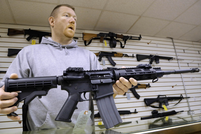 John Jackson, co-owner of Capitol City Arms Supply, shows off an AR-15 assault rifle for sale at his business in Springfield, Illinois.   AP-Yonhap News