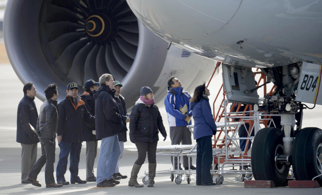 U.S. officials inspect an All Nippon Airways jet that made an emergency landing Wednesday, at Takamatsu airport, western Japan, Friday.   AP-Yonhap News
