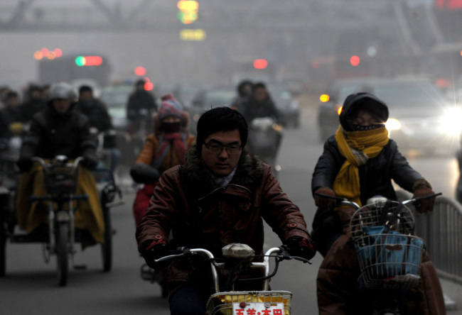 Citizens ride motorcycles amid heavy fog in Zhengzhou City, China.   Xinhua-Yonhap News