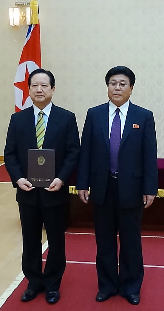 In this photograph released by Pyeonghwa Motors on Tuesday, Pyeonghwa Motors CEO Park Sang-kwon (left) poses with Cha Hui-rim, chairman of the Pyongyang City People’s Committee, at the Mansudae Assembly Hall in the North Korean capital, after receiving an honorary citizenship from Cha on Dec. 18, 2012.   Yonhap News