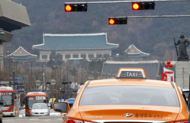 Taxis and buses run on a main boulevard near Gwanghwamun Plaza, downtown Seoul, Tuesday.   Yonhap News
