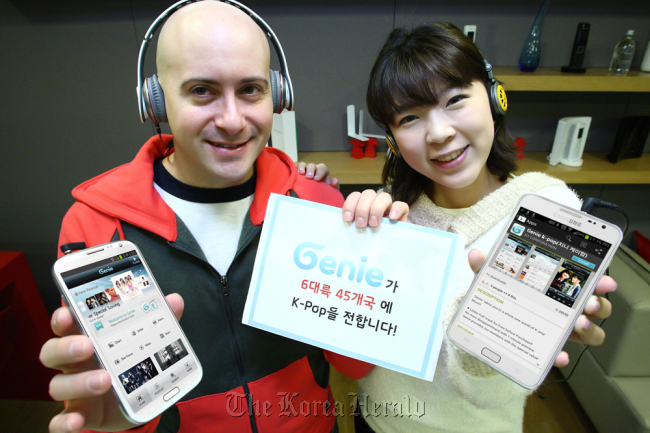 Two KT officials celebrate the global launch of the company’s smartphone-only music app service called “Genie K-POP” in Seoul last week.   KT