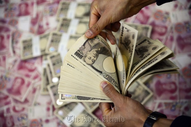 An employee from Korea Exchange Bank in Seoul counts Japanese yen on Wednesday.   Park Hae-mook/The Korea Herald
