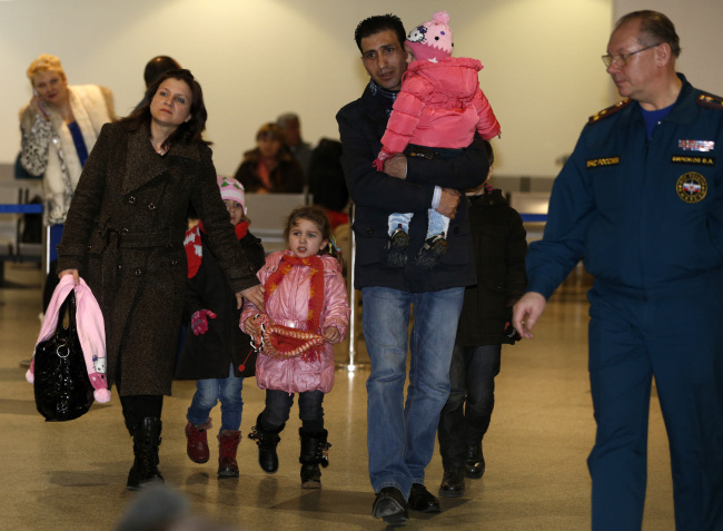 A Russian-Syrian family leaves a passport control zone just after their arrival from Beirut in Moscow Domodedovo airport in Russia on Wednesday.   AP-Yonhap News