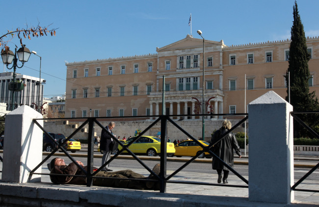 <YONHAP PHOTO-0002> A man sleeps in the main Athens' Syntagma square in front of the Greek parliament on Friday, Dec. 28, 2012. Homelessness has risen sharply since the start of the country's major financial crisis three years ago. (AP Photo/Thanassis Stavrakis) /2012-12-29 00:04:53/ <저작권자 ⓒ 1980-2012 ㈜연합뉴스. 무단 전재 재배포 금지.>
A man sleeps in the main Athens’ Syntagma square in front of the Greek parliament.   Bloomberg