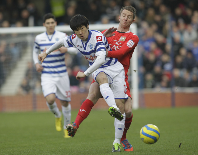 Queens Park Rangers’ Park Ji-sung competes with Milton Keynes Dons’ Dean Bowditch during their English FA Cup on Saturday.    AP-Yonhap News