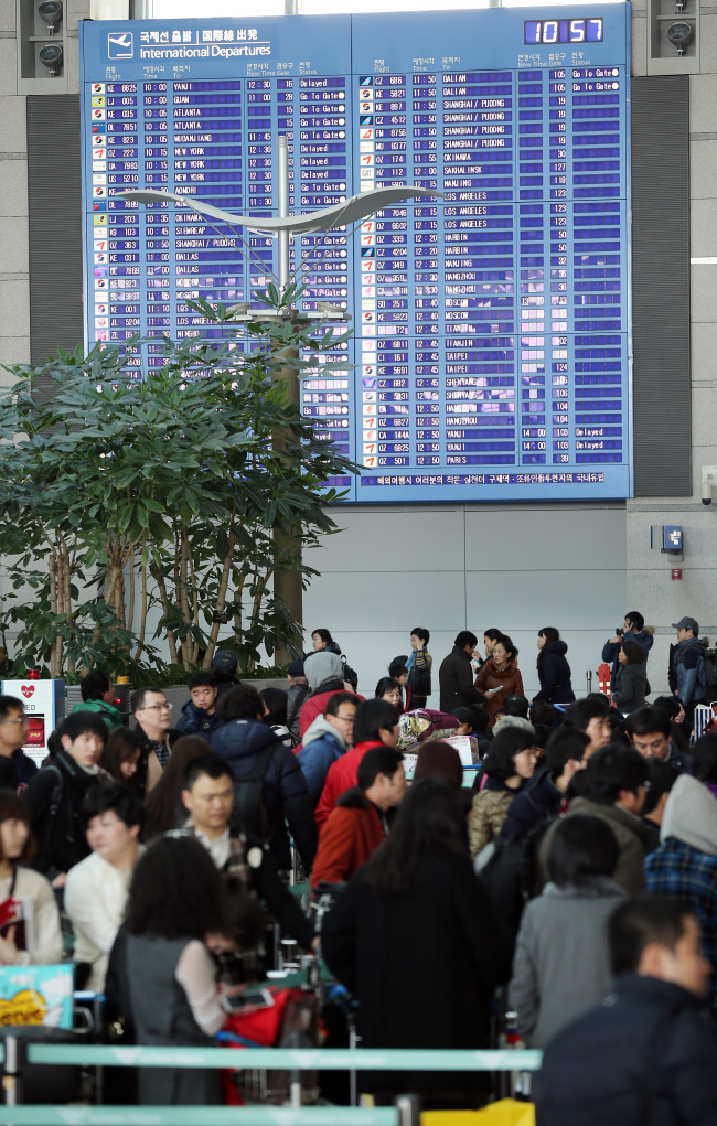 People wait for flights at Incheon International Airport on Dec. 30, 2012. Yonhap News