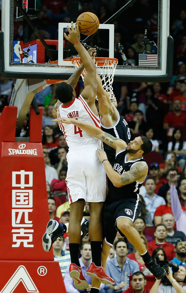 Greg Smith (left) of the Houston Rockets fights for the ball against Kris Humphries and Deron Williams  of the Brooklyn Nets at Toyota Center in Houston on Saturday.   AFP-Yonhap News