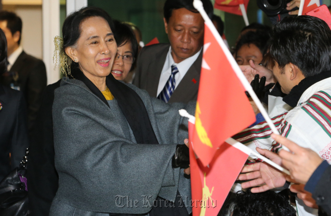 Myanmar's opposition leader Aung San Suu Kyi greets with her countrymen upon her arrival at Incheon International Airport in Korea late Monday. (Yonhap News)