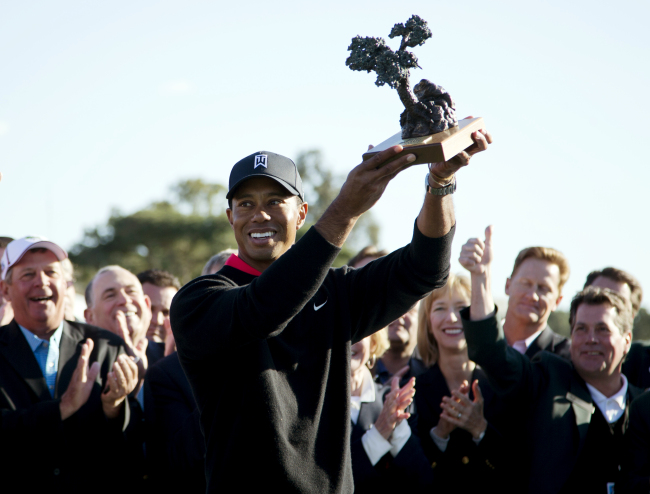 Tiger Woods holds up his trophy after winning the Farmers Insurance Open on Monday.   AP-Yonhap News