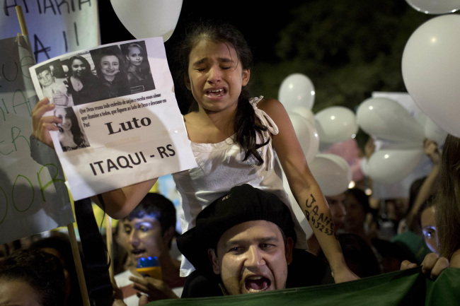 A girl cries during a march in a plaza near the Kiss nightclub honoring the victims of early Sunday’s fatal fire inside the club in Santa Maria, Brazil, Monday.   AP-Yonhap News