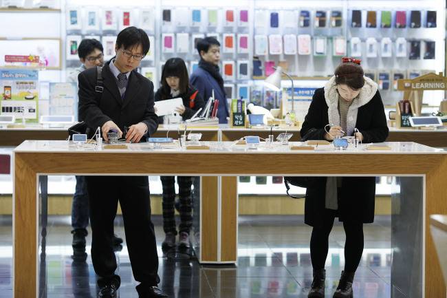 Customers try Samsung Electronics Co. Galaxy Note II smartphones at the Samsung d'light store in Seoul, South Korea, on Wednesday, Jan. 23, 2013. Samsung, in a preliminary statement of results on Jan. 8, reported an 89 percent jump in profit in the three months ended in December, boosted by its Galaxy line of smartphones. Photographer: Woohae Cho/Bloomberg
Customers try Samsung Electronics Co. Galaxy Note II smartphones at the Samsung d’light store in Seoul.    Bloomberg