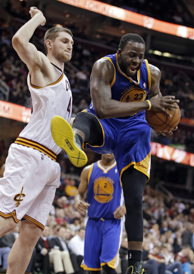 Golden State Warriors’ Draymond Green (right) pulls down a rebound against Cleveland Cavaliers’ Tyler Zeller in the fourth quarter on Tuesday.   AP-Yonhap News