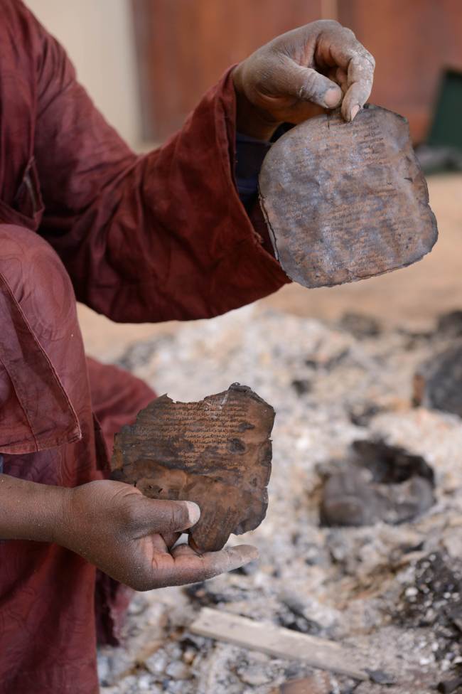 A man recovers burnt ancient manuscripts at the Ahmed Baba Centre for Documentation and Research in Timbuktu on Tuesday. AFP-Yonhap News