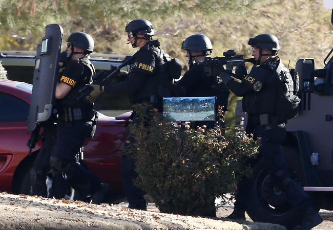 Members of the Phoenix Police Department SWAT team prepare to enter the home of a suspected gunman who opened fire at a Phoenix office building on Wednesday.   AP-Yonhap News