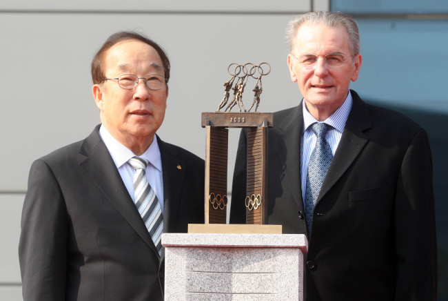 지크로게(Jacques Rogge/스포츠인),박용성(기업인/스포츠인/대한체육회회장)
IOC president Jacques Rogge (right) and Korean Olympic Committee president Park Yong-sung pose behind a miniature version of “The Large Door,” which Rogge donated at the Jincheon Training Center in North Chungcheong Province on Thursday. The original “Door” is on display at the IOC headquarters in Lausanne, Switzerland.   Yonhap News
