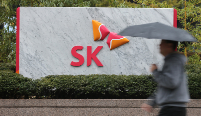 <YONHAP PHOTO-1412> 선장 없는 SK호 (서울=연합뉴스) 안정원 기자 = 최태원 SK 회장의 법정 구속으로 SK그룹이 비상경영체제에 돌입한 가운데 1일 시민이 서린동 SK 사옥을 지나고 있다 . 2013.2.1 jeong@yna.co.kr/2013-02-01 15:00:08/Media Only <저작권자 ⓒ 1980-2013 ㈜연합뉴스. 무단 전재 재배포 금지.>
A pedestrian walks past the SK Group building in Seolin-dong, downtown Seoul.   Yonhap News